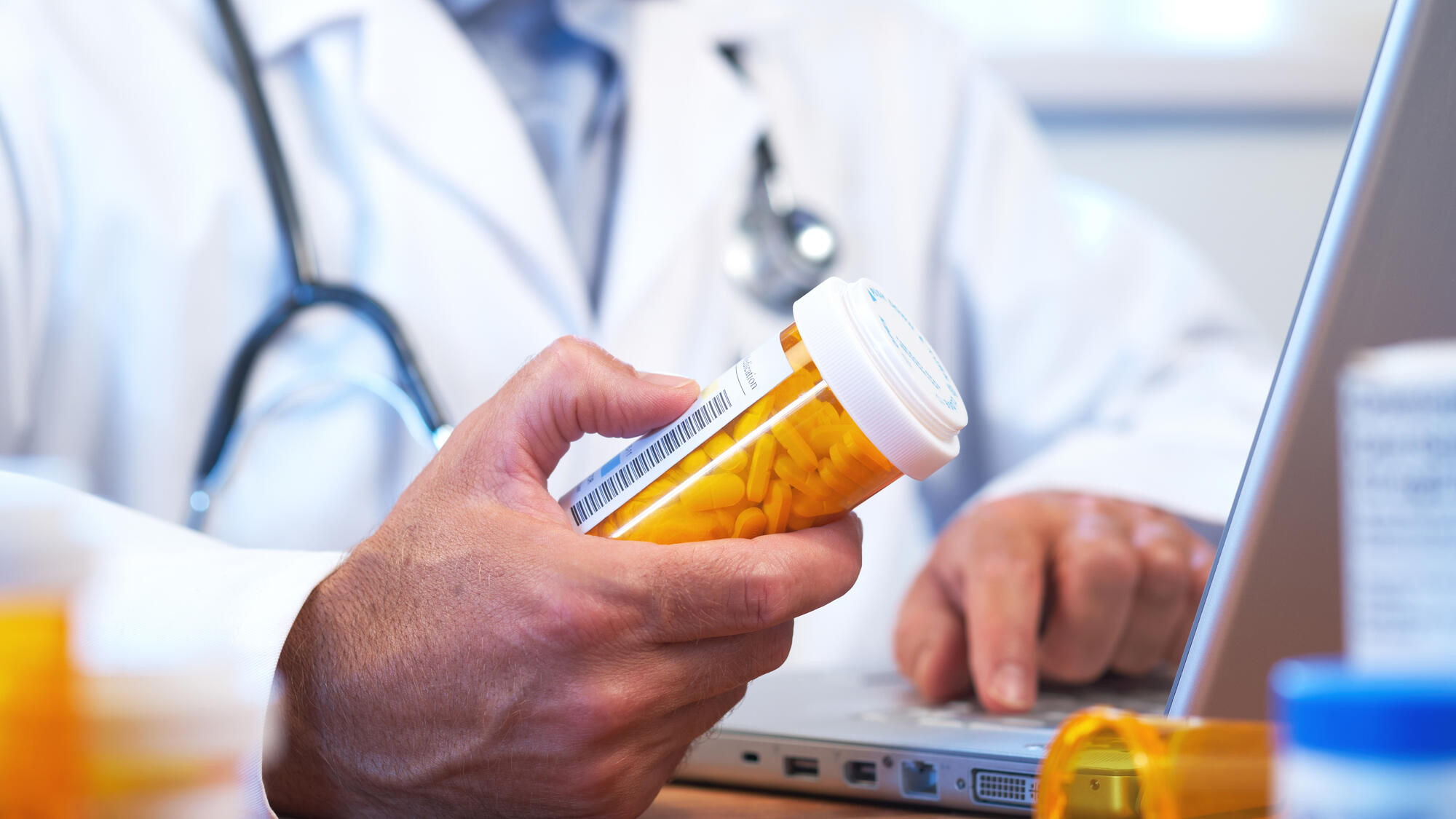 Doctor holding a container of pills